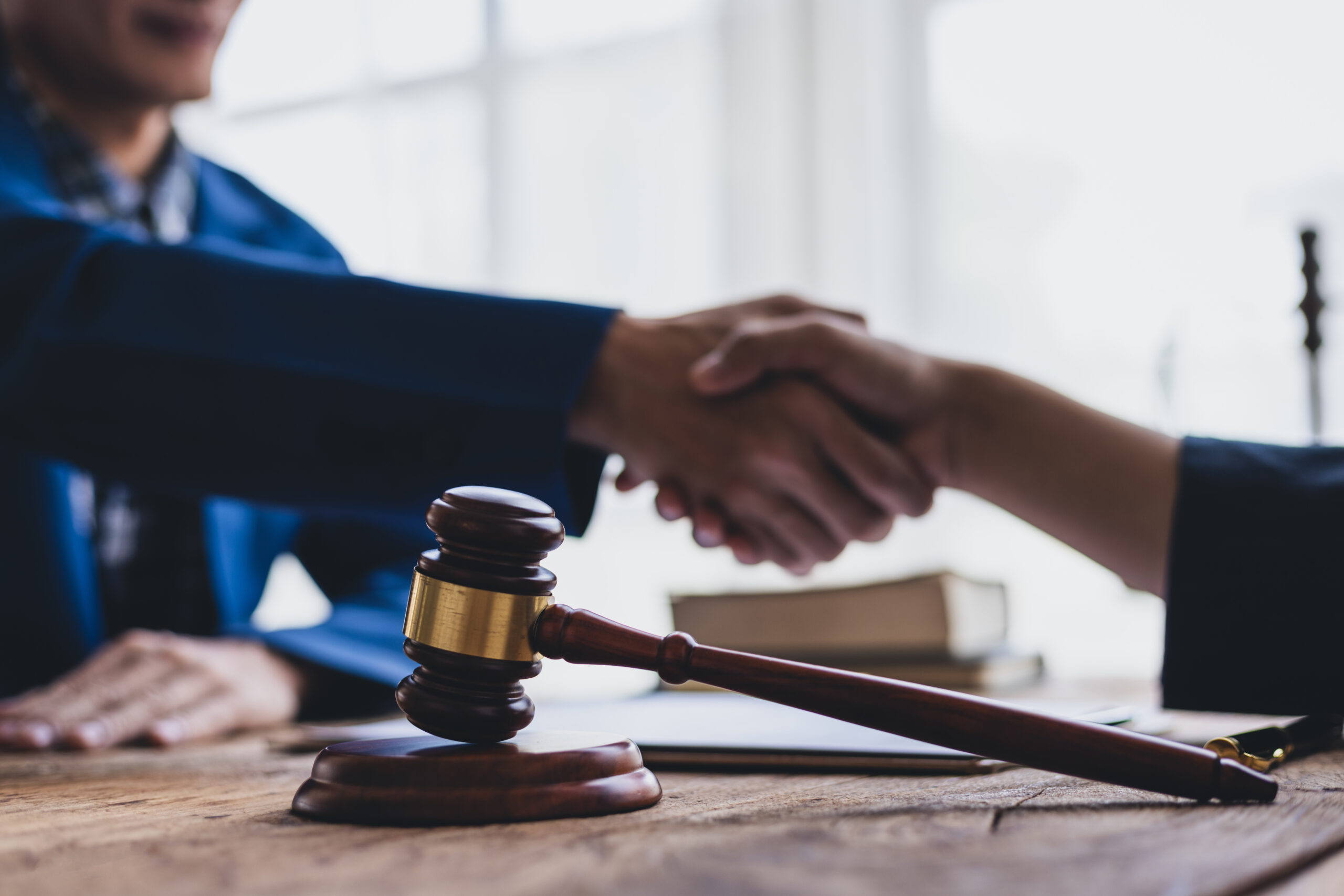 Businessman shaking hands with lawyer after signing legal agreement contract.